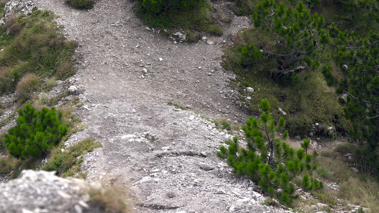 一名徒步旅行者正沿着一个倾斜的岩石斜坡上山。视频下载