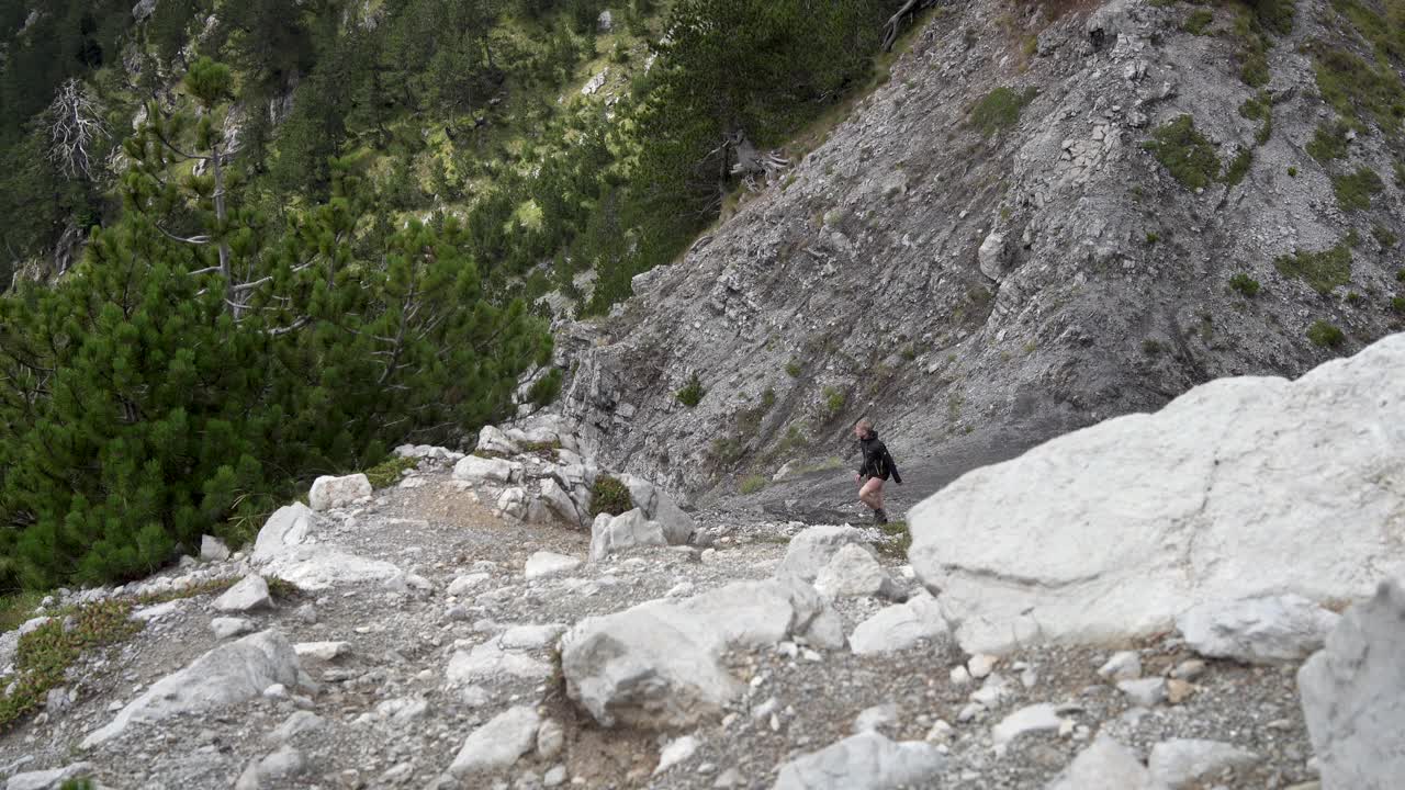 徒步旅行者登山的概念是在石质斜坡上攀登。视频下载