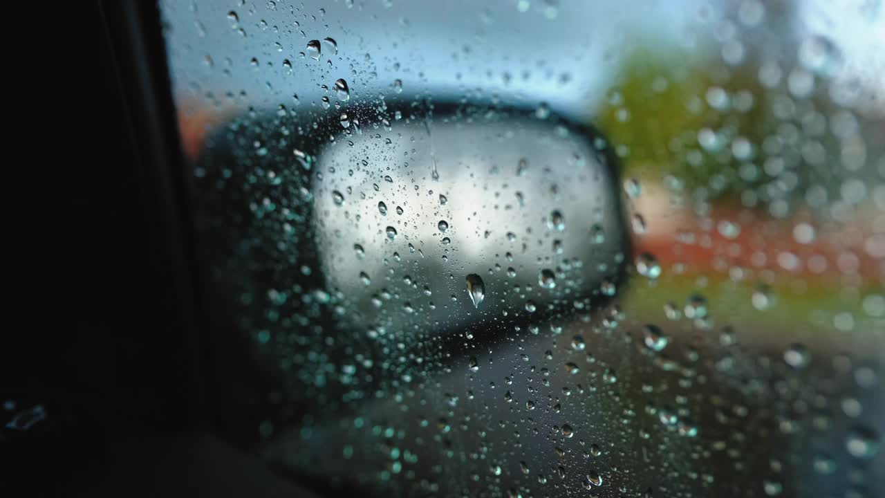 雨点在汽车玻璃上的背景汽车镜子视频素材