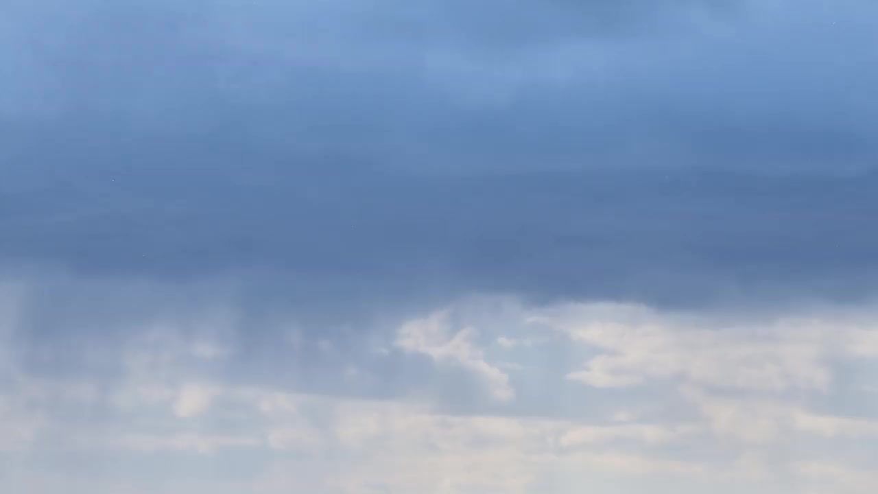 蓝色天空上的轻云变成了黑色的雨旋风，时间流逝的背景。天气从晴天变成了阴云，夹杂着雨和冰雹视频素材