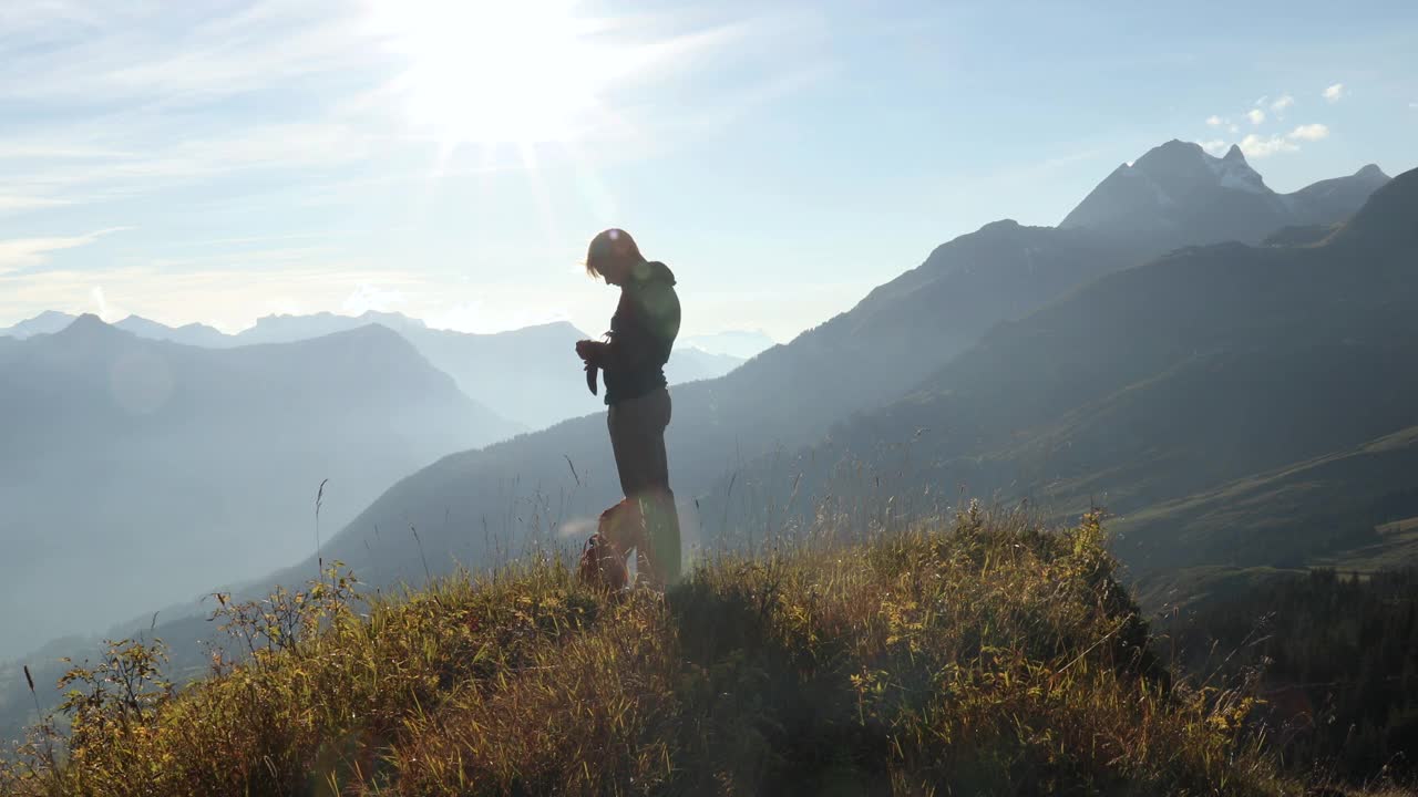 男性徒步旅行者在长满草的山顶上散步视频素材