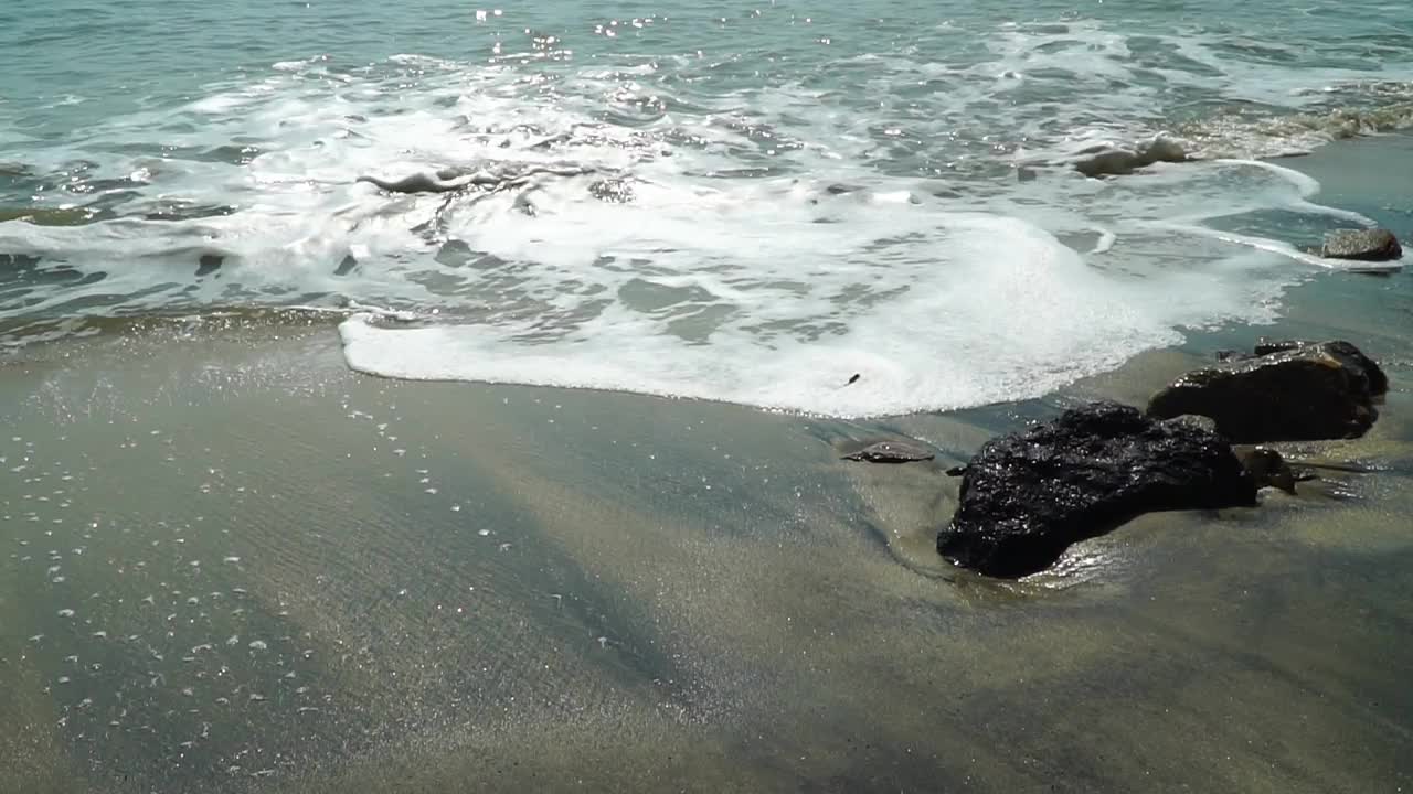 海浪在清晨的阳光下拍打着海岸。视频下载