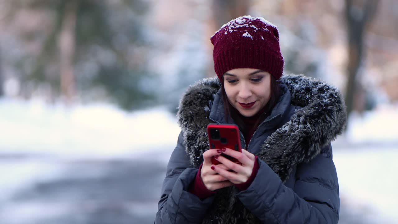 一个女人在雪域公园查看电话留言视频素材