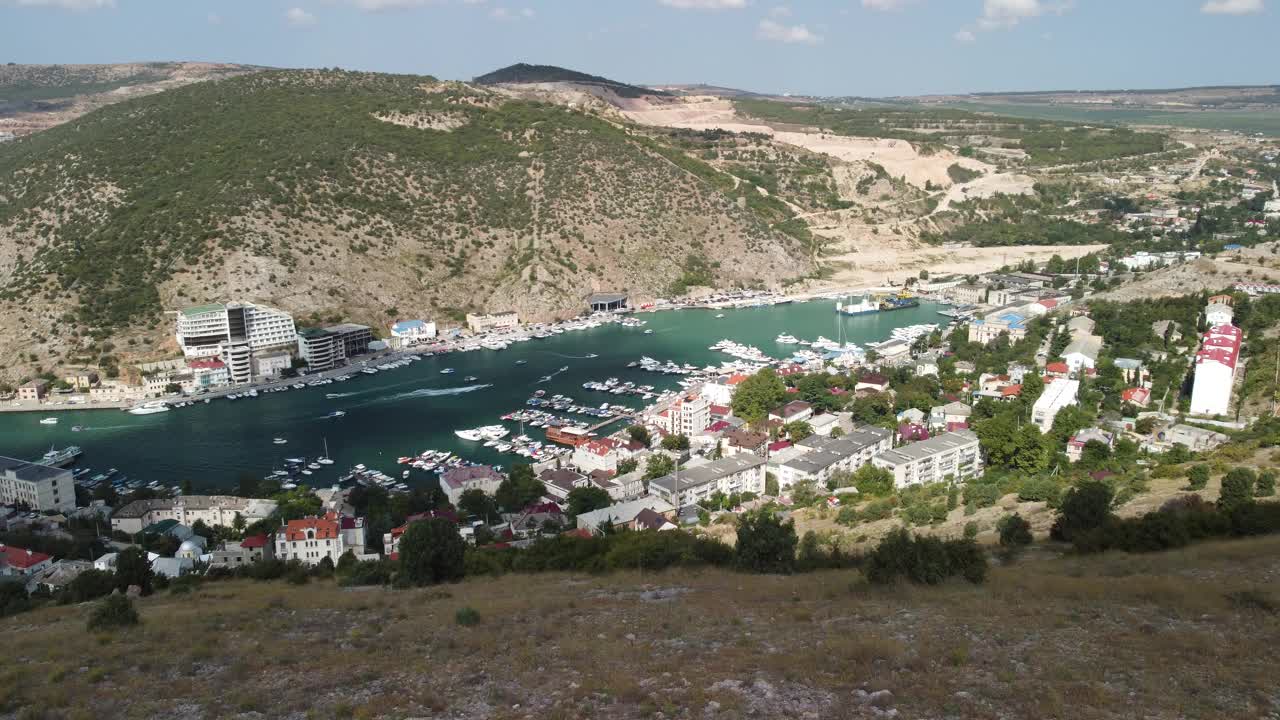 鸟瞰巴拉克拉瓦风景与船和海在滨海湾。克里米亚塞瓦斯托波尔旅游景点。无人机俯视图拍摄的港口豪华游艇，船只和帆船视频素材