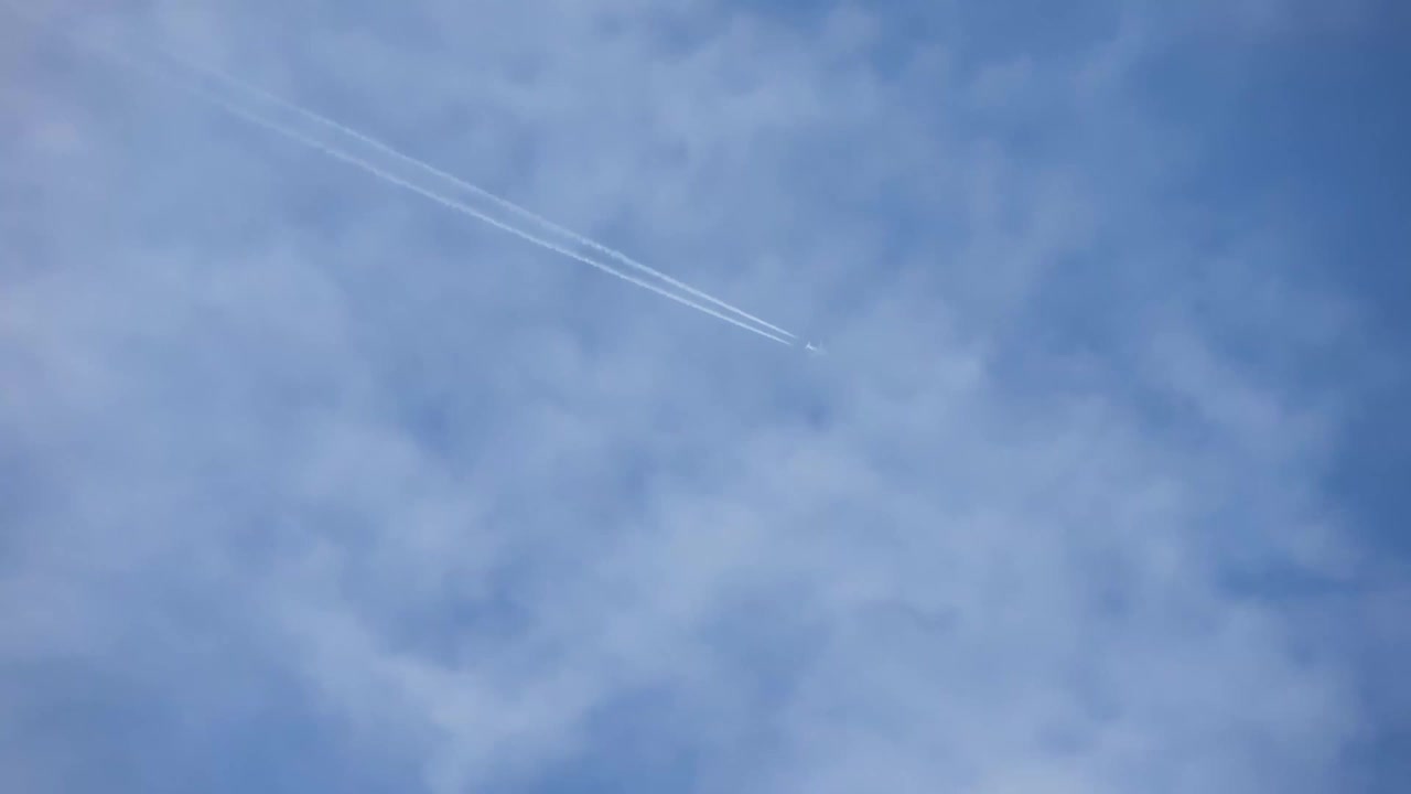 高空飞行的喷气式客机在清澈的蓝天上留下了尾迹。视频素材