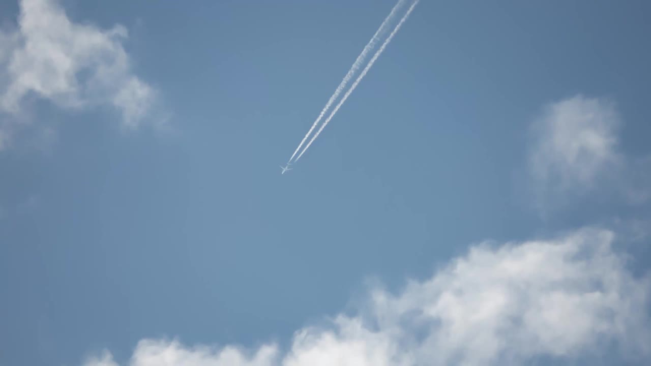 高空飞行的喷气式客机在清澈的蓝天上留下了尾迹。视频素材