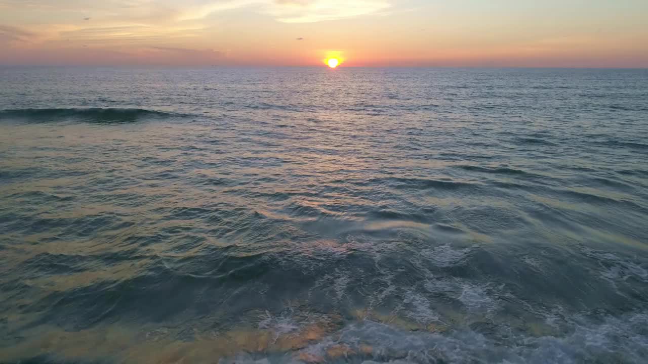 日落在海湾海浪鸟瞰自然海景日落光戏剧性的乌云日落天空无人机拍摄高角度视图视频素材