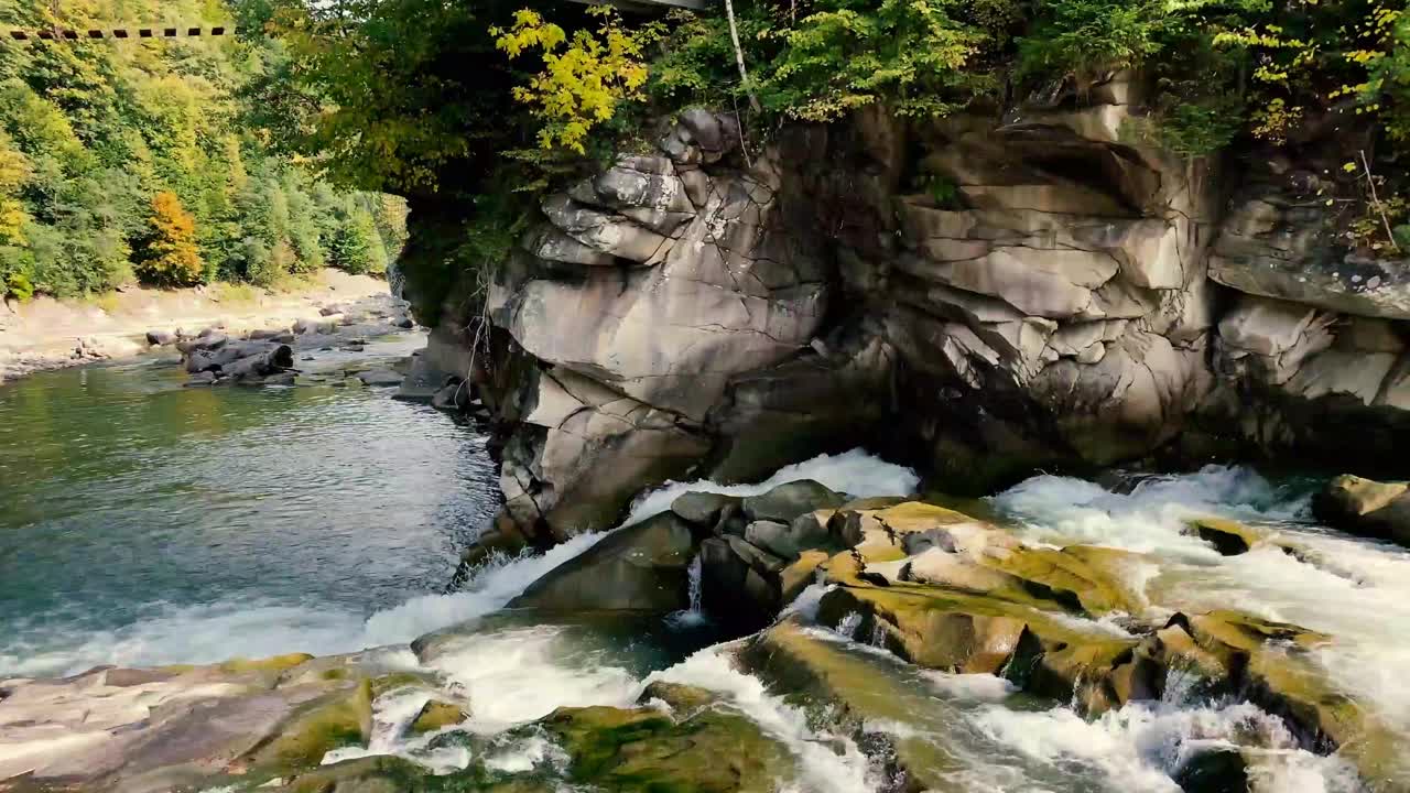 在乌克兰喀尔巴阡山脉，秋天的山河在美丽的森林中流淌视频素材