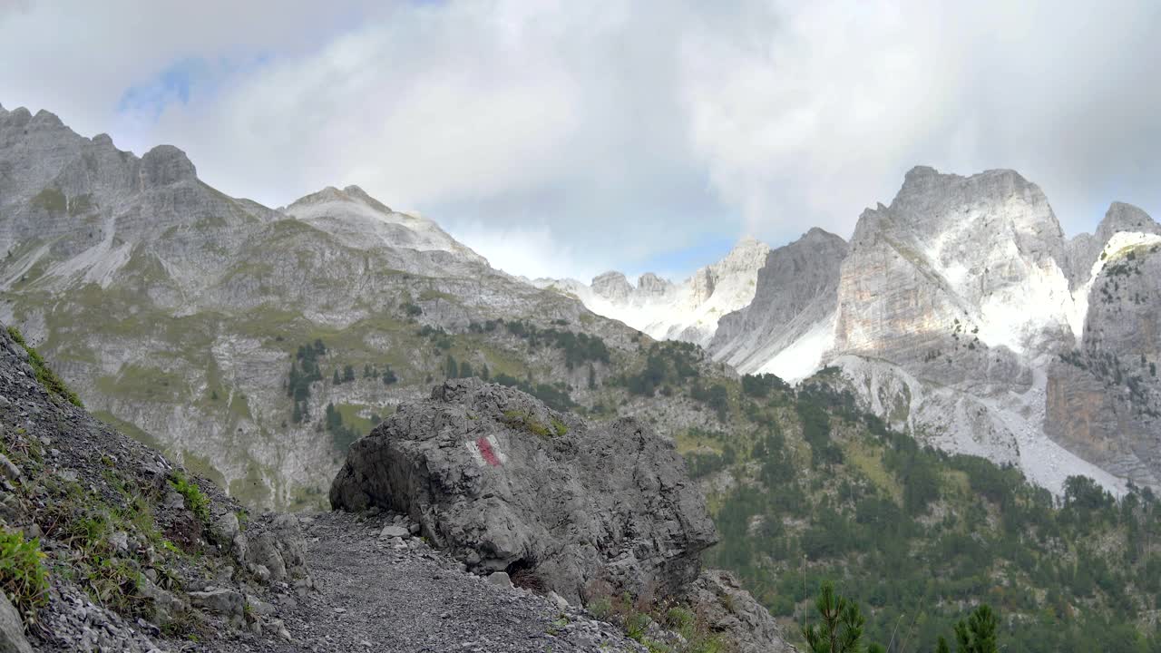 徒步旅行者正走在布满岩石的山谷中。视频下载