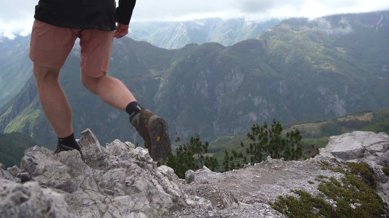 徒步旅行者从落基山脉的斜坡上走下来。视频下载