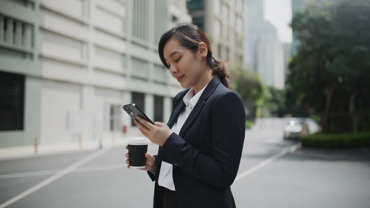 亚洲女商人在城市使用手机视频素材