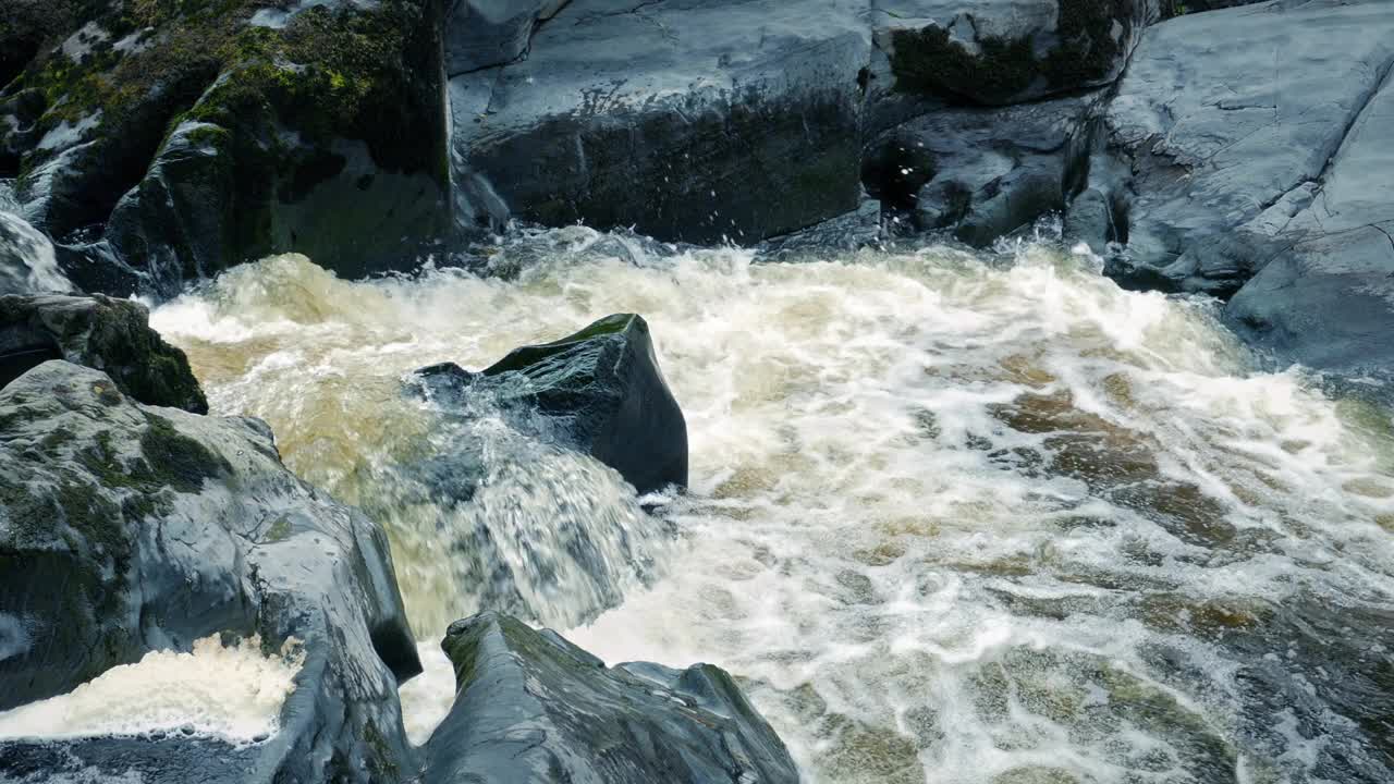 山间岩石间泛起泡沫的河流视频素材