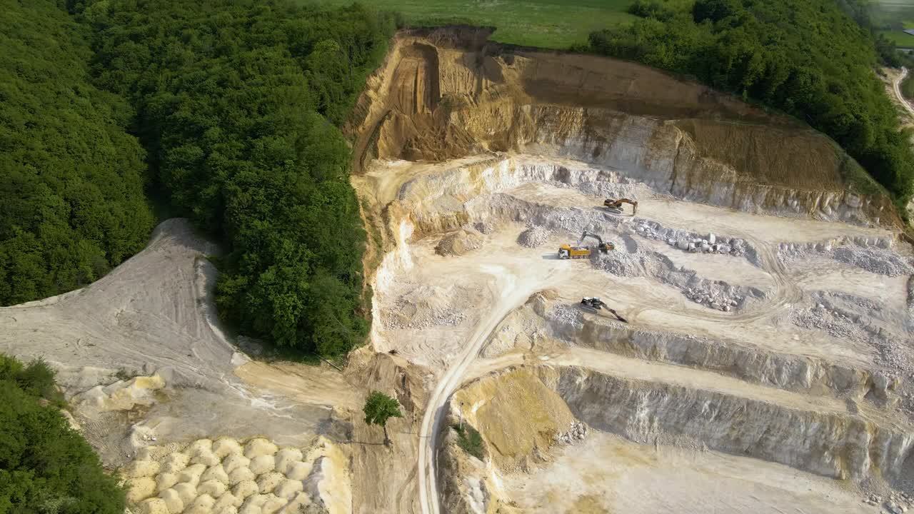 露天开采建筑砂石材料用挖掘机和自卸卡车。视频素材