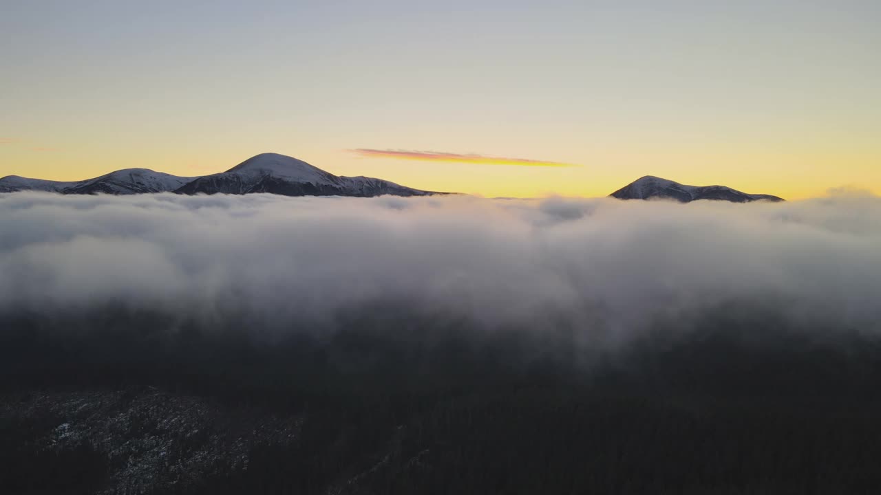 鸟瞰生机勃勃的日出在白色的浓雾与遥远的喀尔巴阡山脉的黑暗山峰在地平线上。视频素材