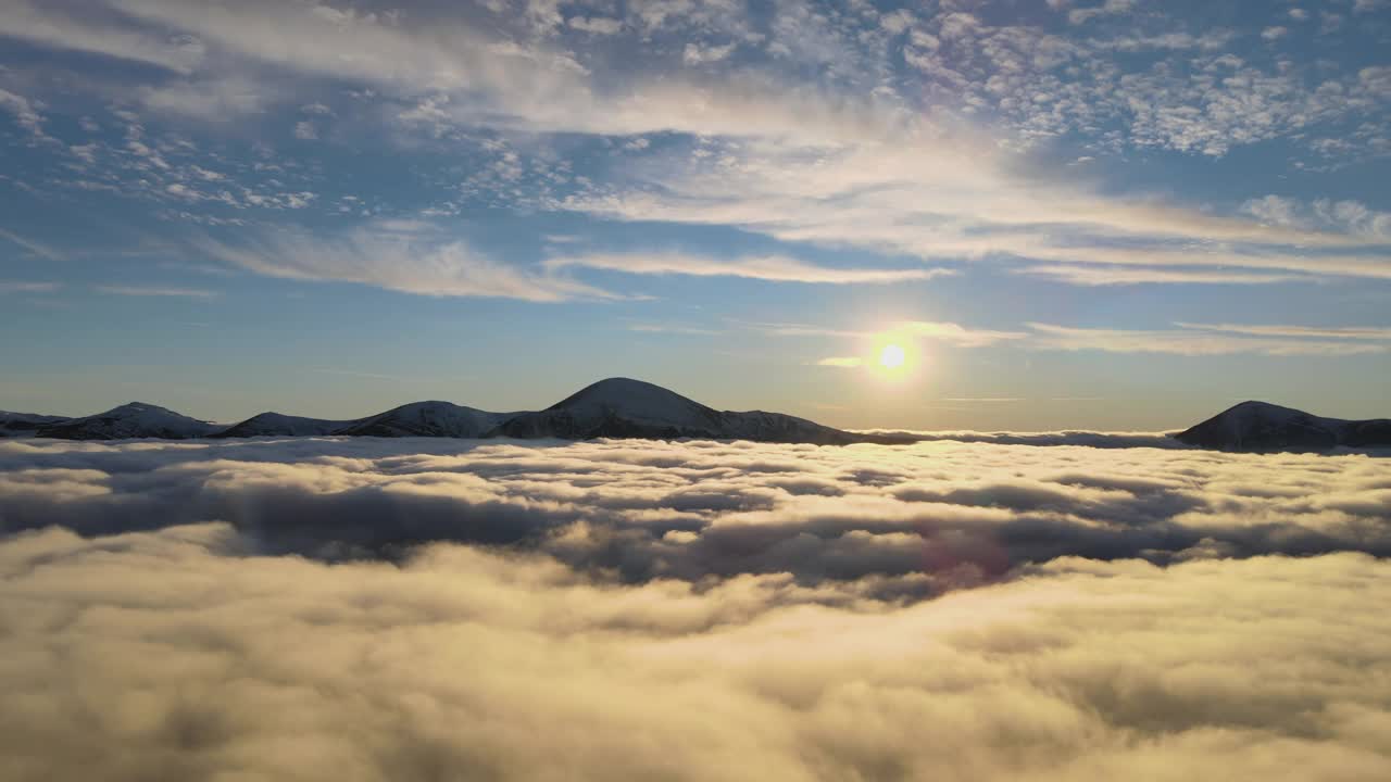 鸟瞰图的生机勃勃的日出在白色浓密的云与遥远的黑暗的山脉在地平线上。视频素材