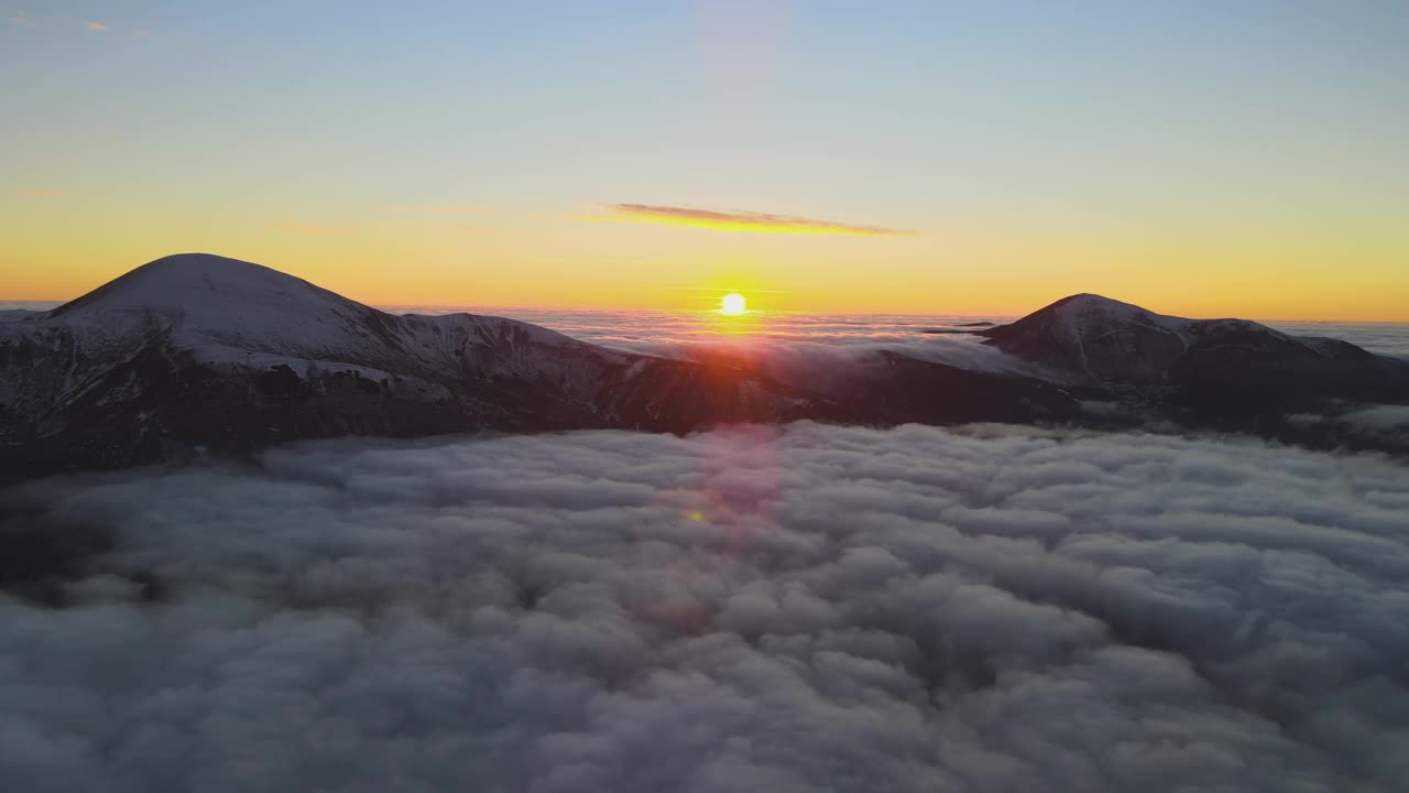 鸟瞰生机勃勃的日出在白色的浓雾与遥远的喀尔巴阡山脉的黑暗山峰在地平线上。视频素材