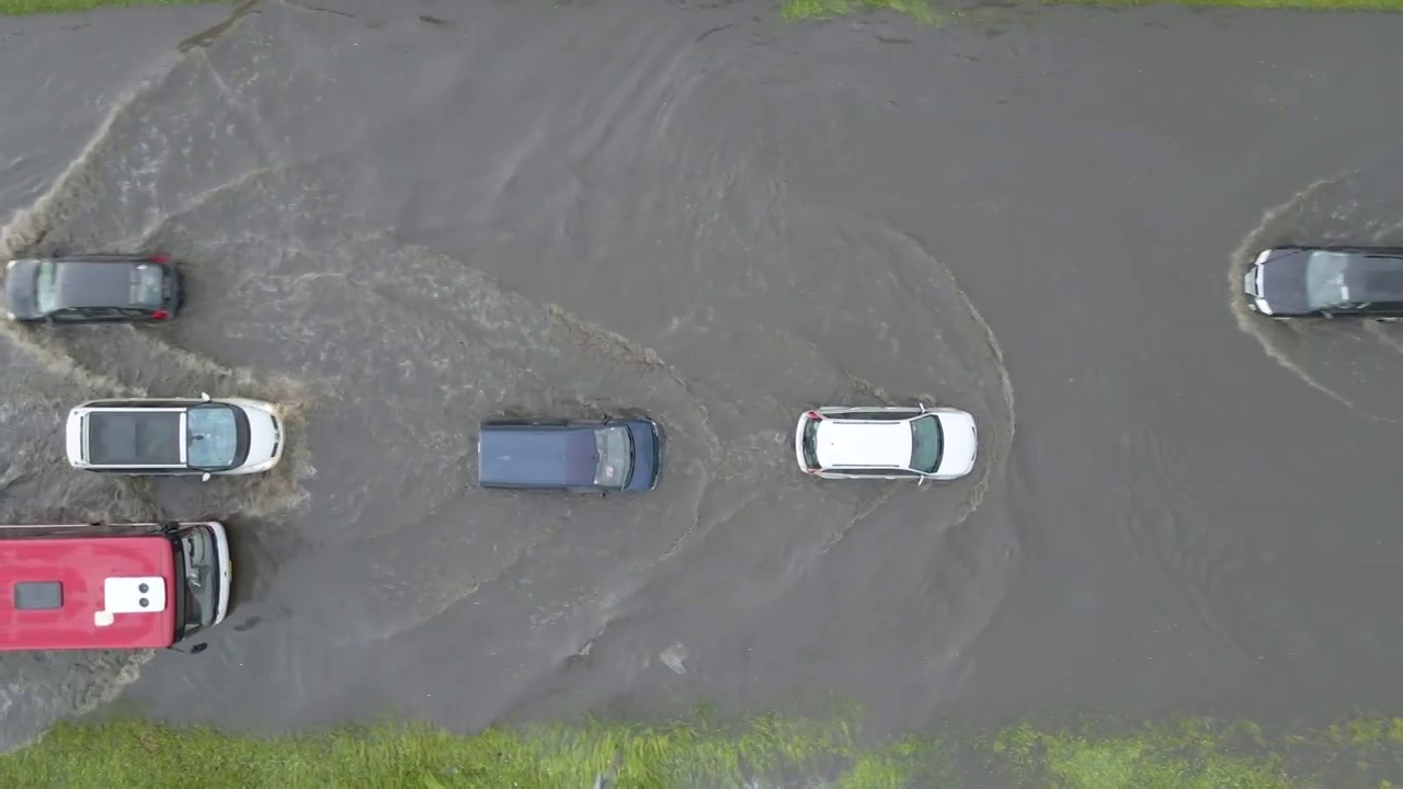 鸟瞰图的城市交通与汽车行驶在洪水后的街道。道路排水系统问题。视频素材