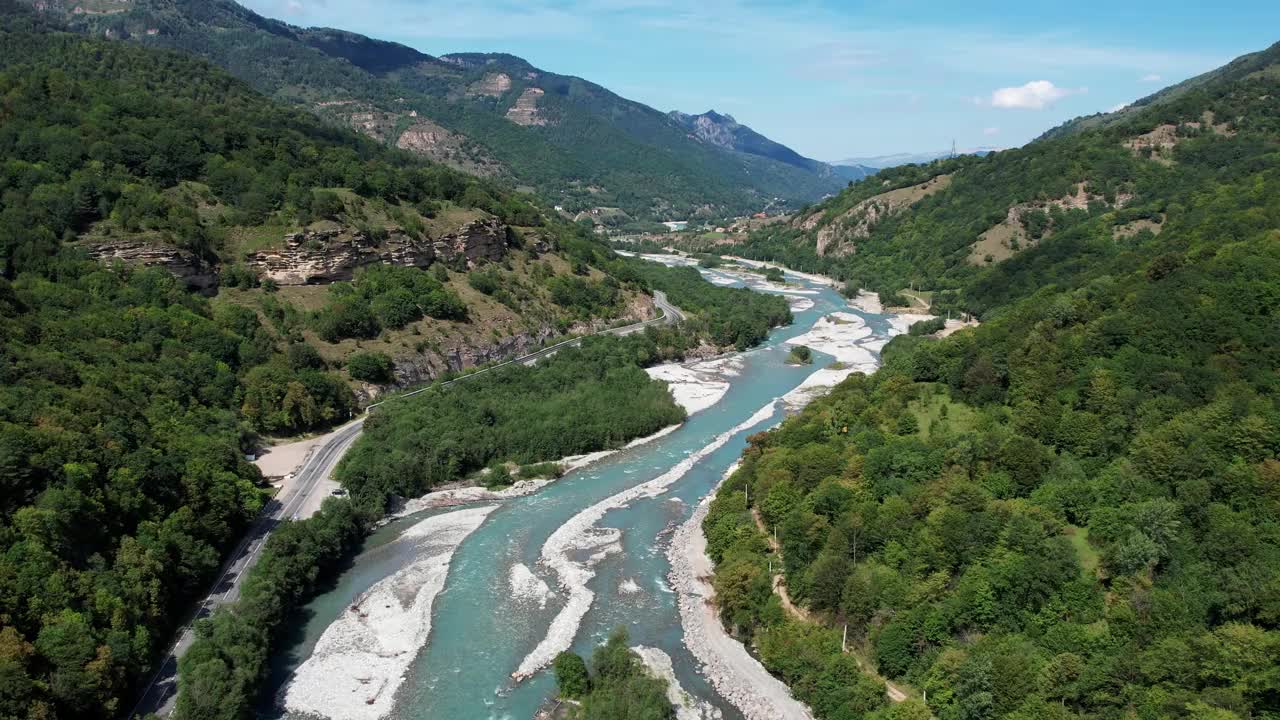 空中全景镜头的山河与绿松石冰川水流经绿色山谷视频素材