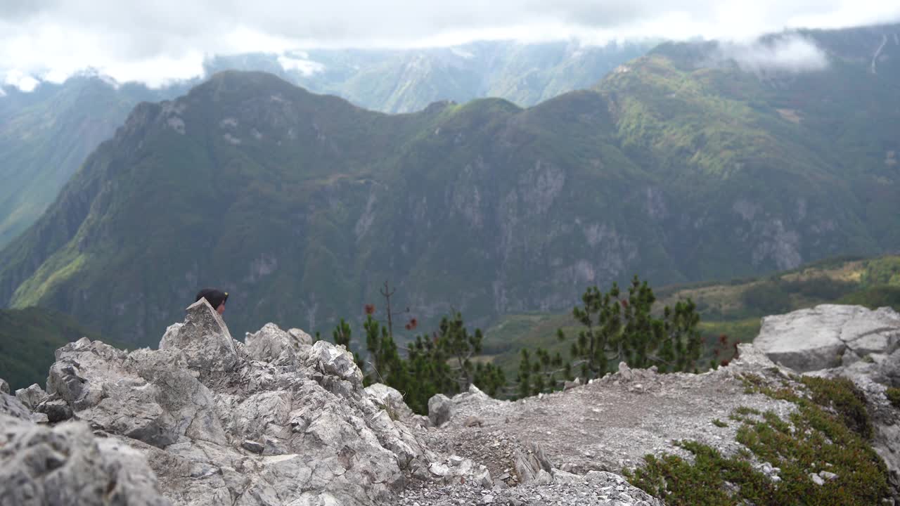 徒步旅行者正在山谷中攀登，环顾四周。视频下载