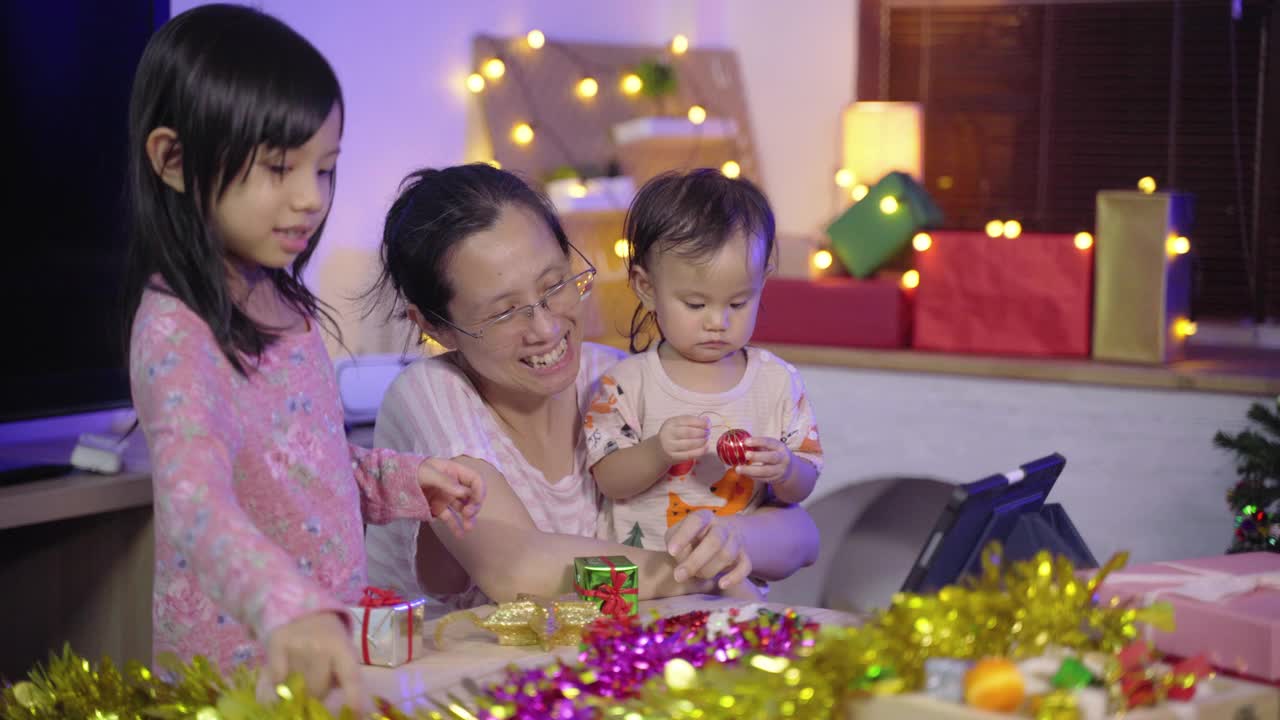 亚洲妇女与两个女孩使用笔记本电脑视频通话在庆祝圣诞节假期派对视频素材