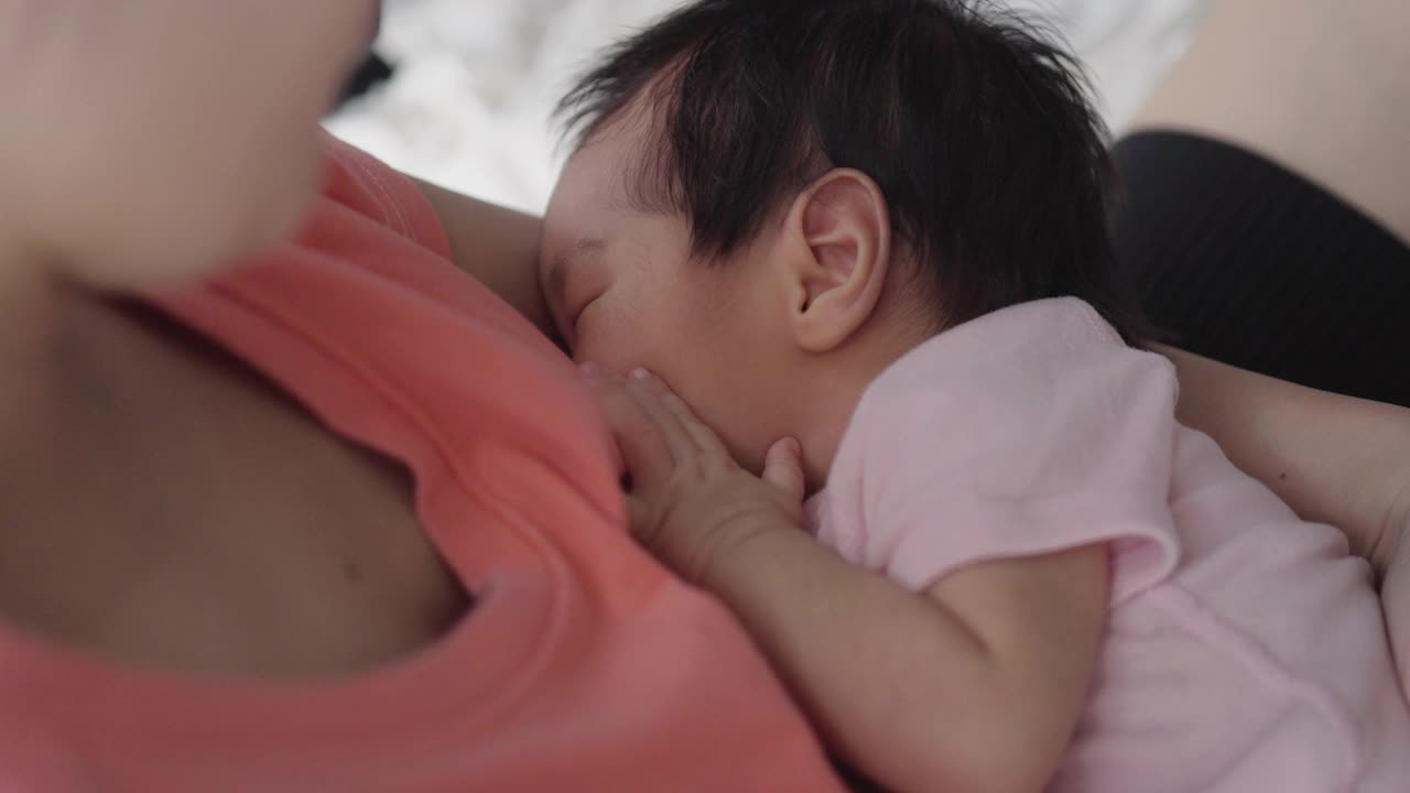 亚洲妇女坐着给她的小宝贝喂奶视频下载