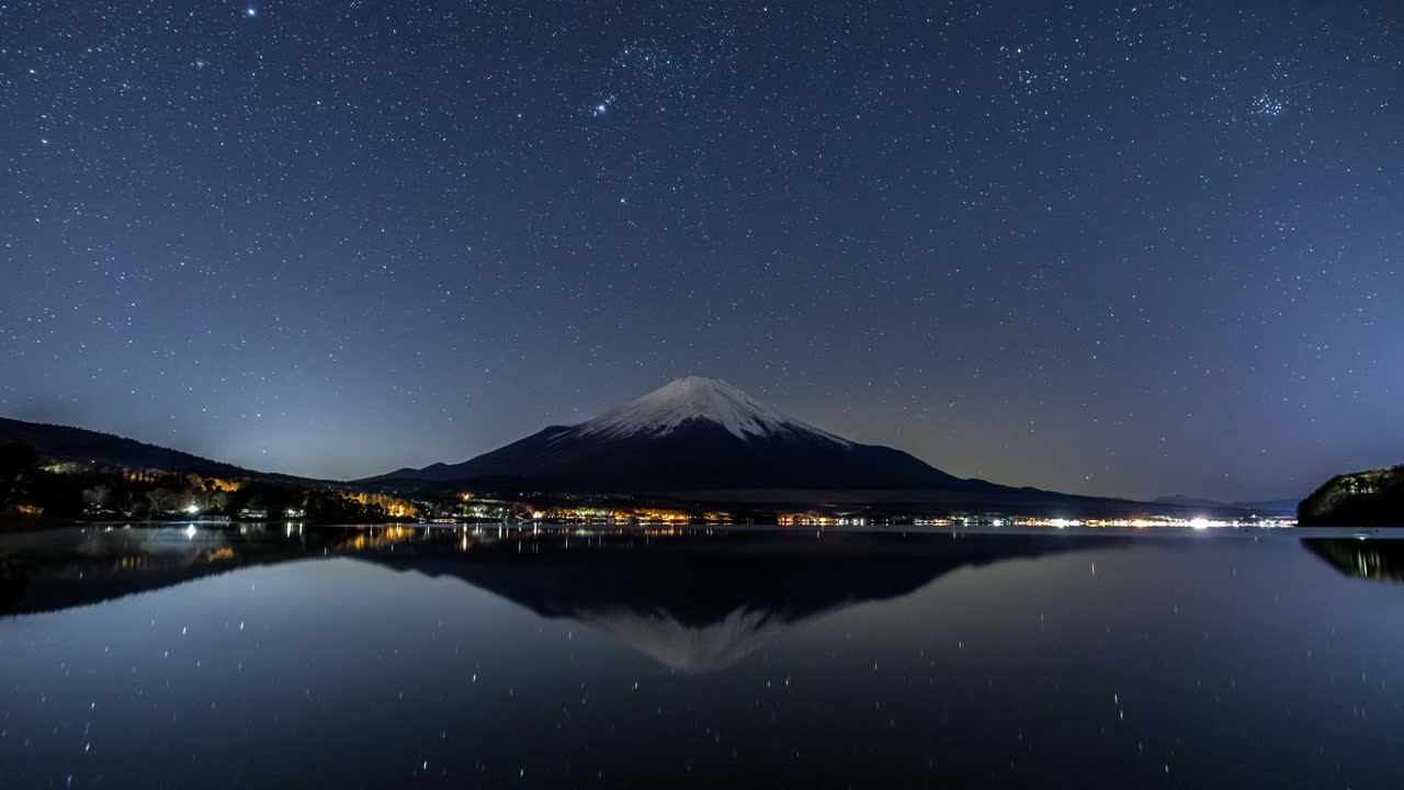 富士山倒映在山中湖的湖面上，冬日的星空下，时光流逝视频素材