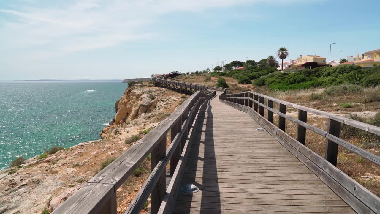 沿着木路散步，你会看到夏天葡萄牙卡沃埃罗海岸的美妙景色。俯瞰蓝色的大海。用稳定器在运动中射击。视频素材