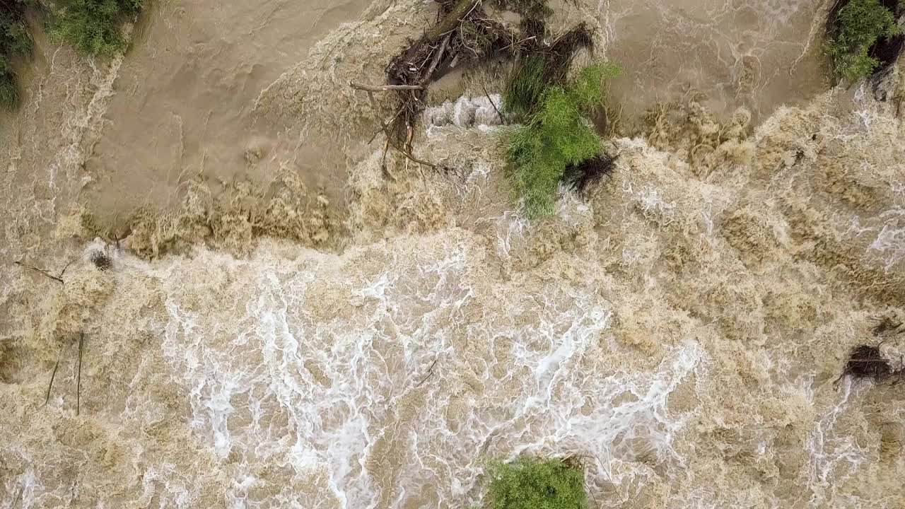 鸟瞰图宽阔的肮脏的河流与泥泞的水在洪水期间在暴雨的春天。视频素材