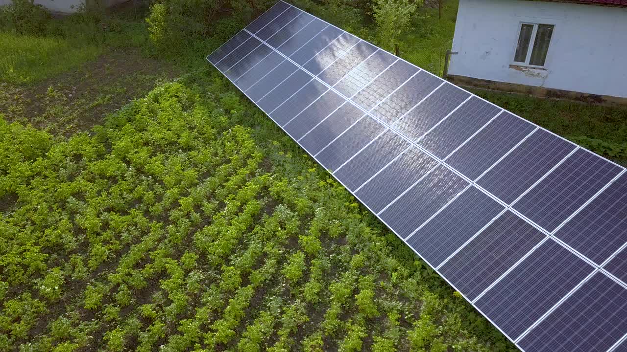 绿色草地上的蓝色太阳能板提供清洁能源。视频素材