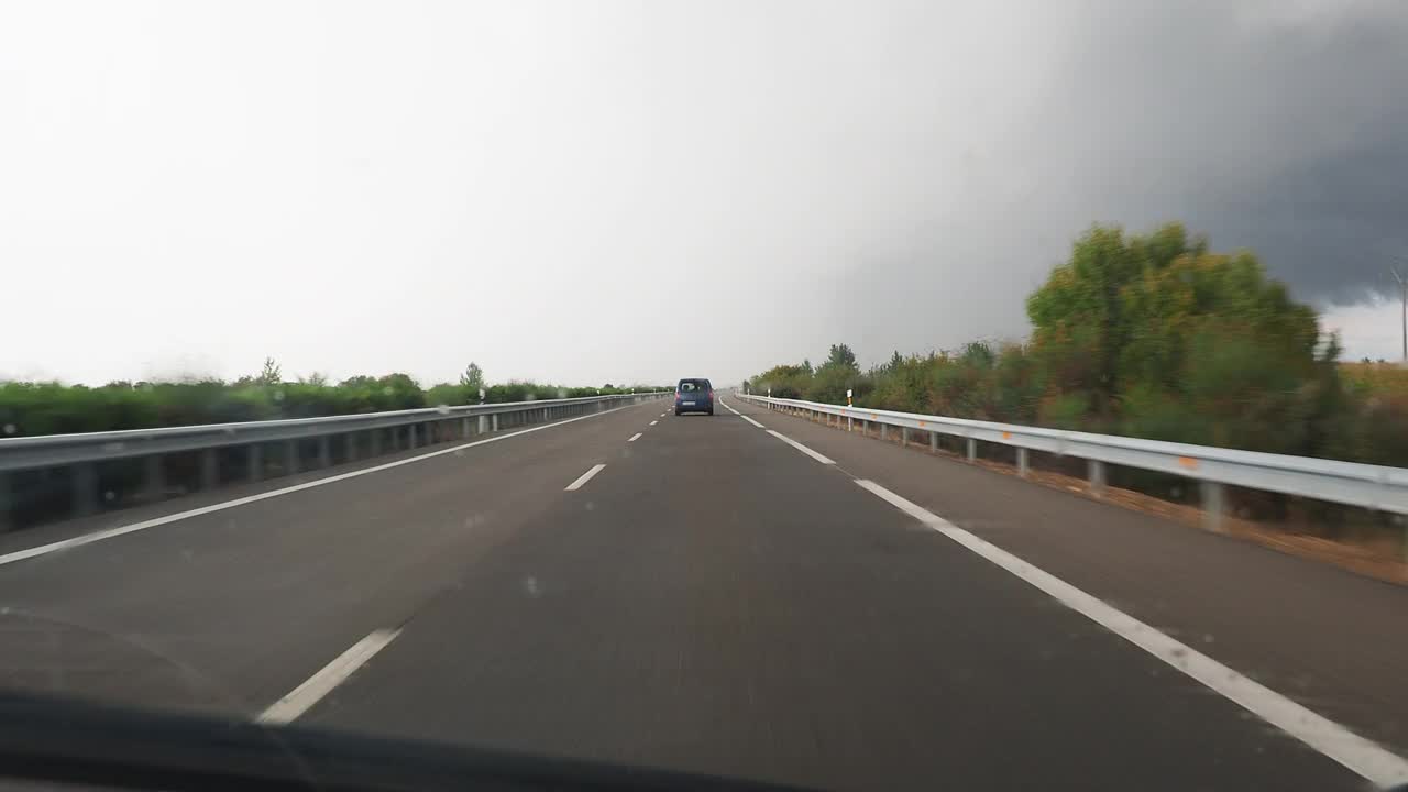 车的观点行驶在下雨的公路和挡风玻璃雨刷擦雨视频素材