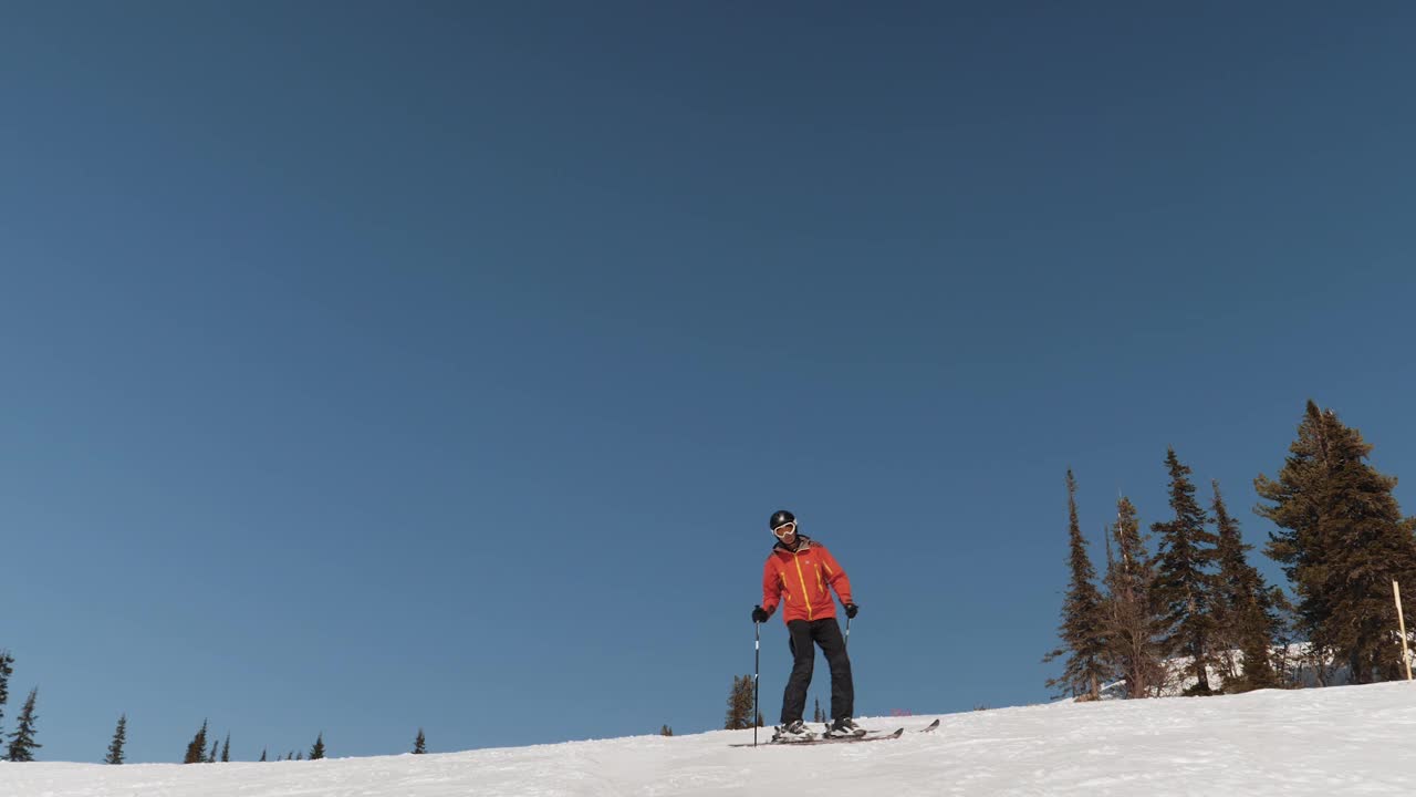 动态滑雪者在雪道上滑雪在山区度假胜地冬季在阳光明媚的日子视频素材