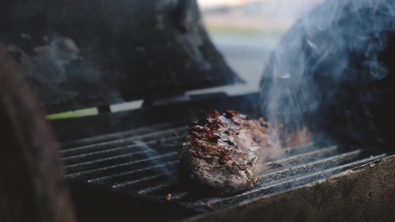 厨师在木炭烤架上用火焰烤肉，并把牛排放在烤架上视频素材