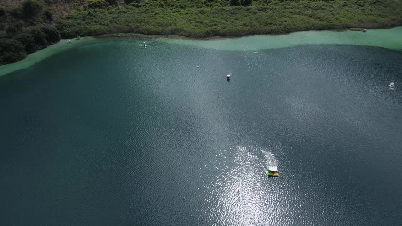 无人机拍摄的湖泊，漂浮的双体船背景的海岸线。视频素材