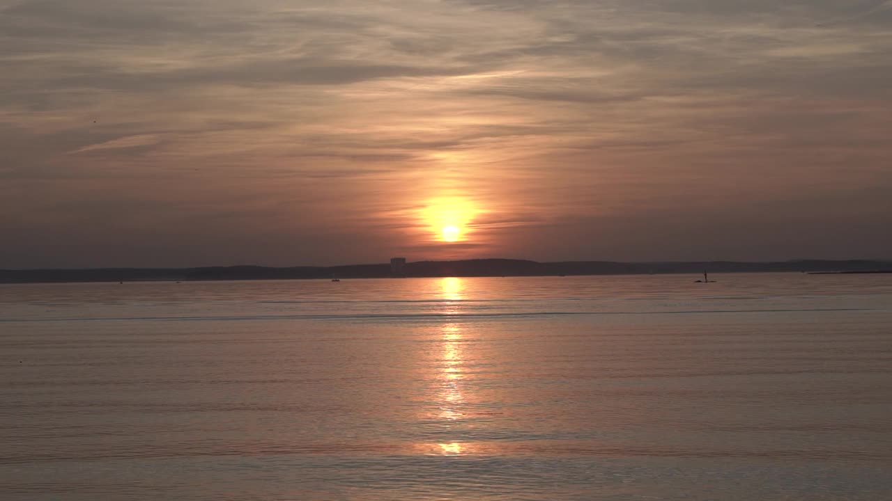 湖上的日落。在晴朗的天气里，平静温暖的夕阳落在城市外的夏日湖泊上。放松冷静自然视频视频素材