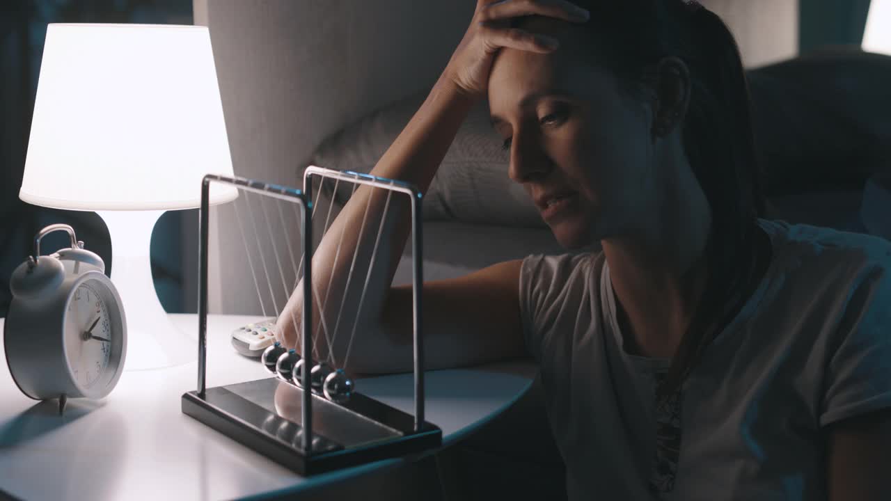 饱受失眠折磨的可怜女人盯着牛顿的摇篮视频素材