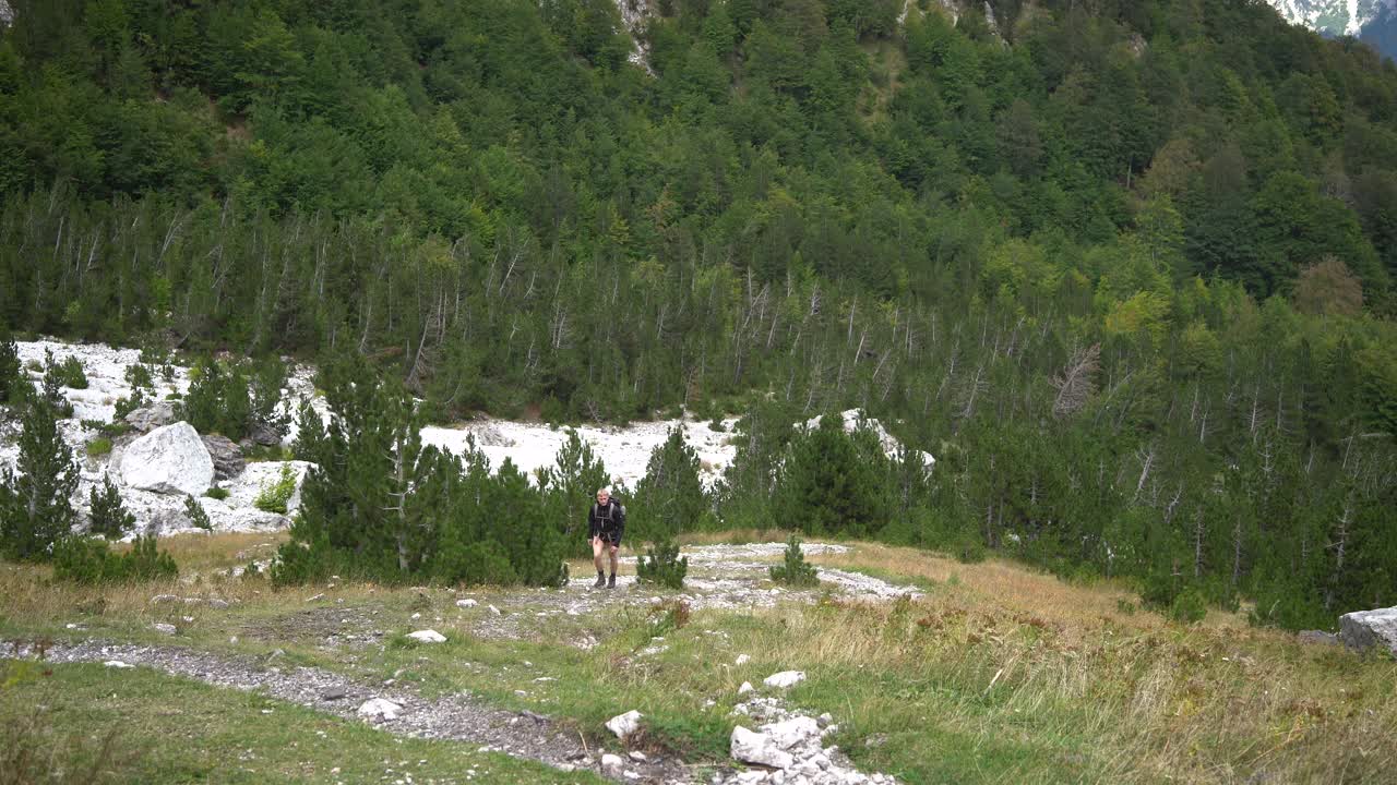 疲惫的徒步旅行者背着背包上山，徒步旅行的概念。视频下载