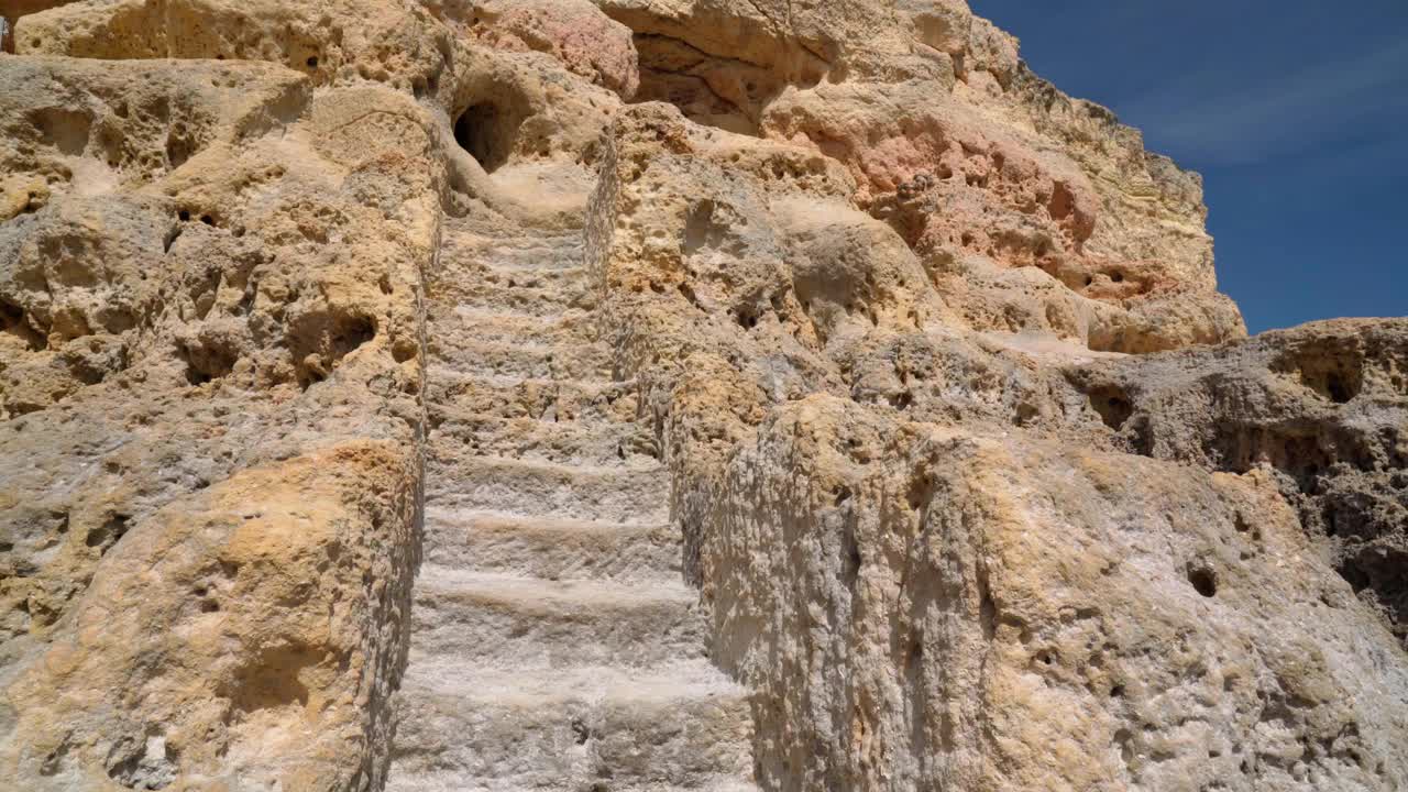 沿着葡萄牙海岸阿尔加维区(Carvoeiro)的山石小径和隧道行走。视频素材