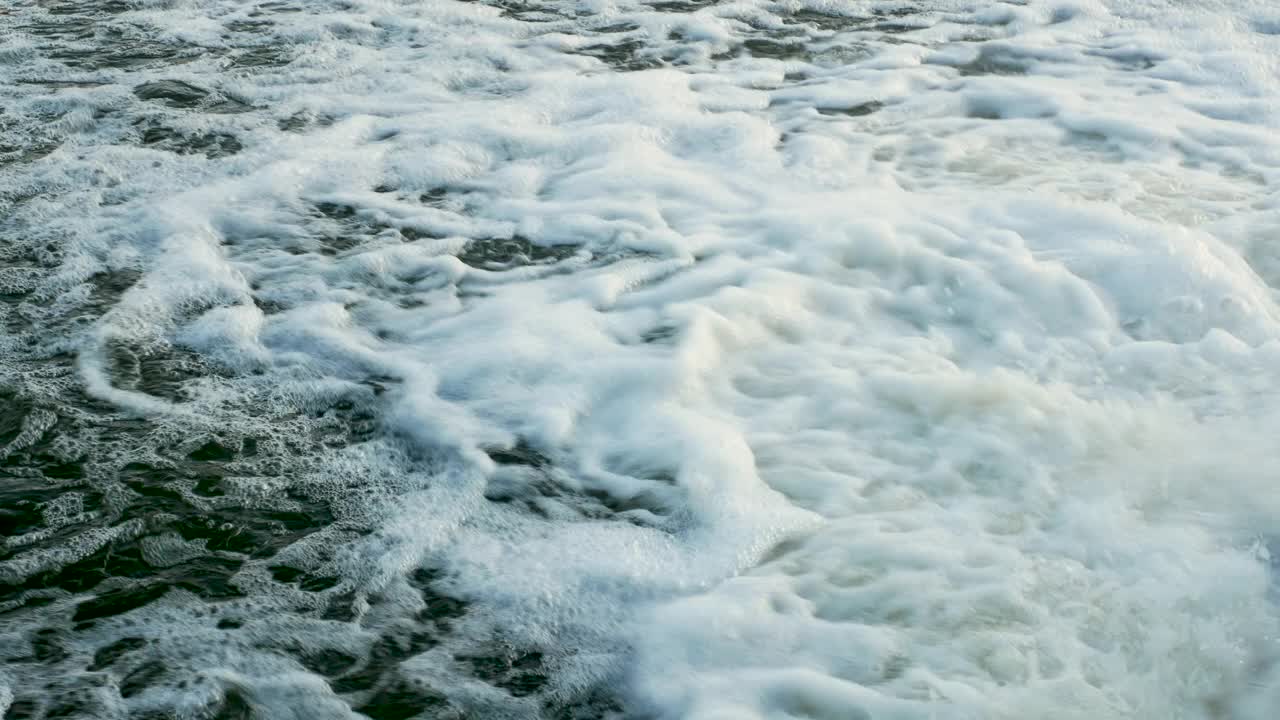 河中的水沸腾着白色的泡沫，背景水泡沫，森林瀑布流入河中。视频素材