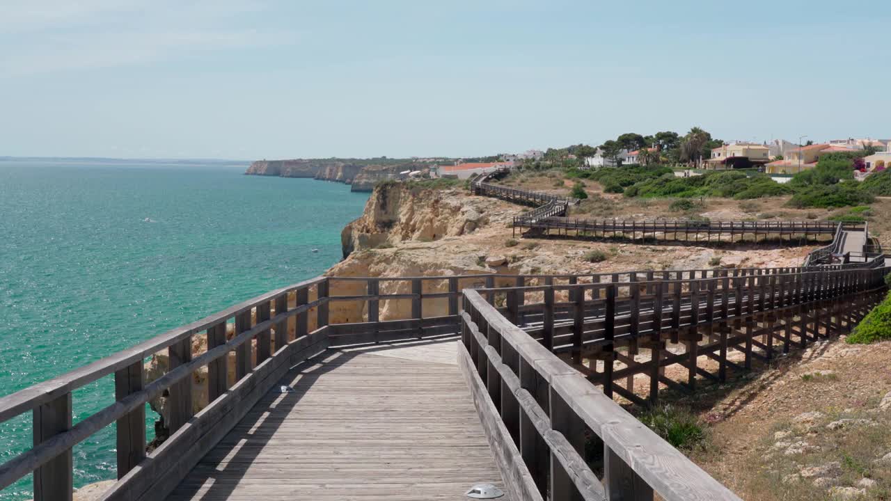 沿着木路散步，你会看到夏天葡萄牙卡沃埃罗海岸的美妙景色。俯瞰蓝色的大海。用稳定器在运动中射击。视频素材