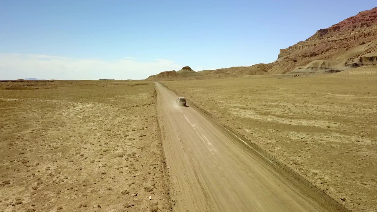 空中:沙漠道路上的越野车的美丽镜头，无人机飞越半干旱的景观在棉白杨峡谷- Page，亚利桑那州视频素材