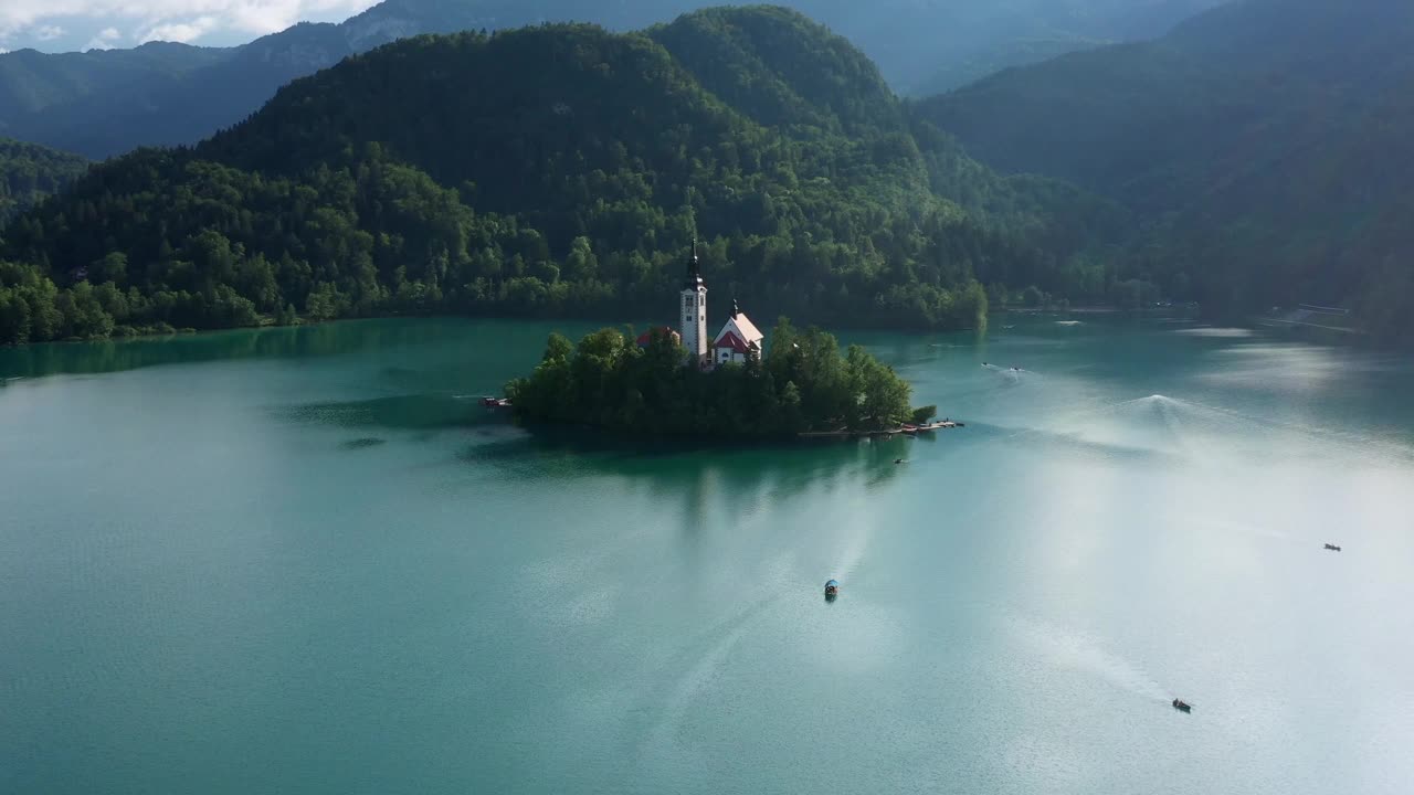 空中美丽的照片教堂在绿树在岛上，无人机飞过著名的湖流血视频素材