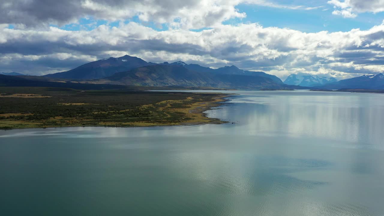 空中前进的美丽镜头，山在多云的天空-纳塔莱斯港，智利视频素材