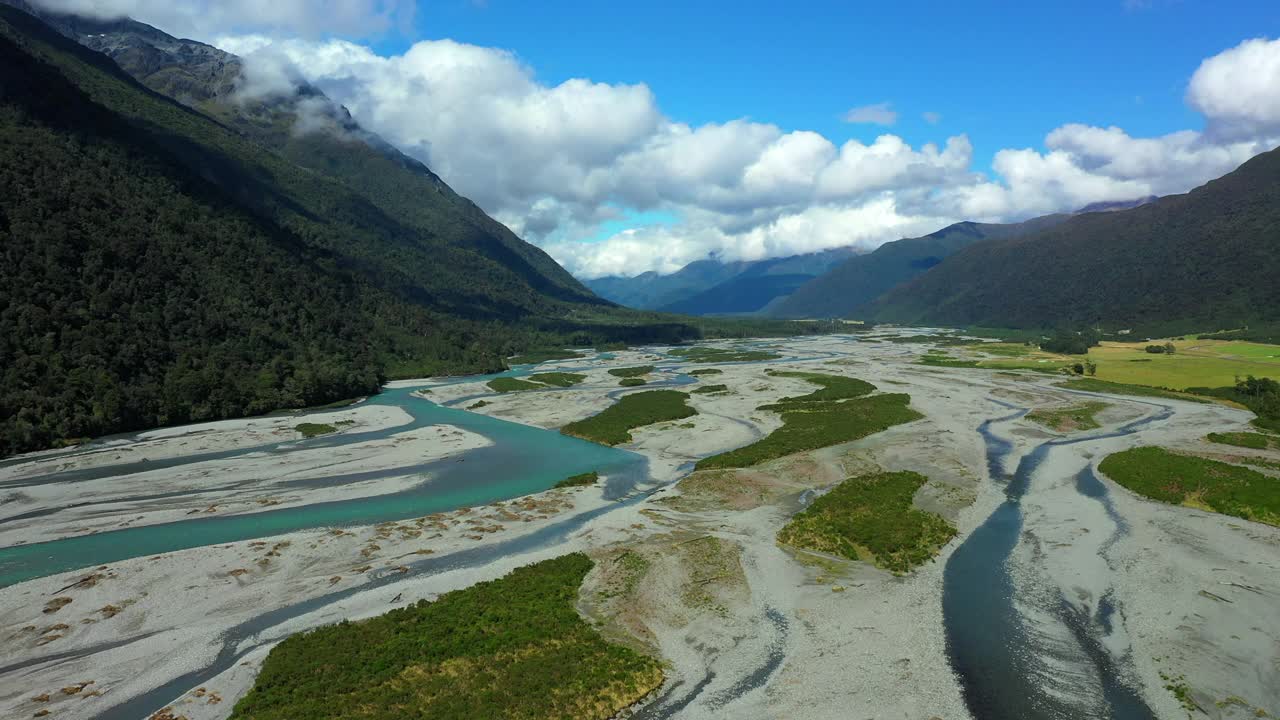 空中:在绿色山脉中河流的田园诗般的景色，无人机在阳光下飞过风景-奥克兰，新西兰视频素材