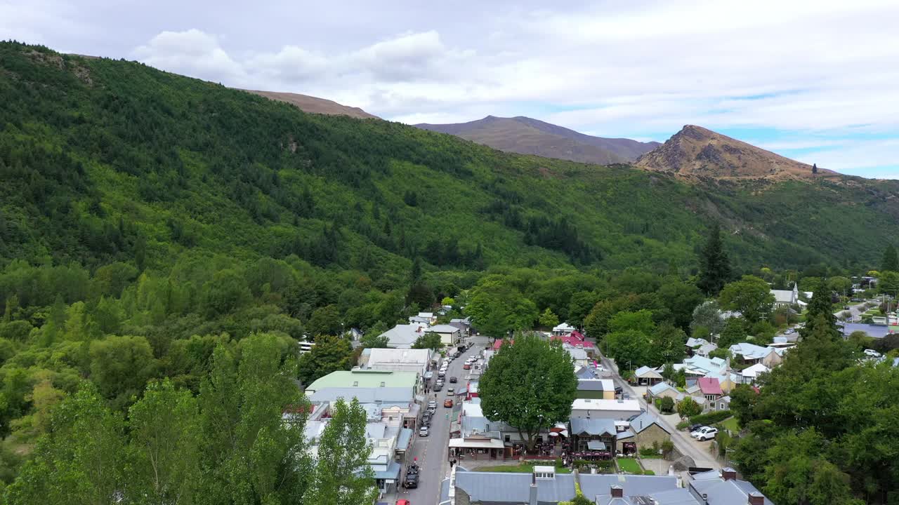 空中前进拍摄的车辆在道路上的住宅，无人机飞过绿树-奥克兰，新西兰视频素材