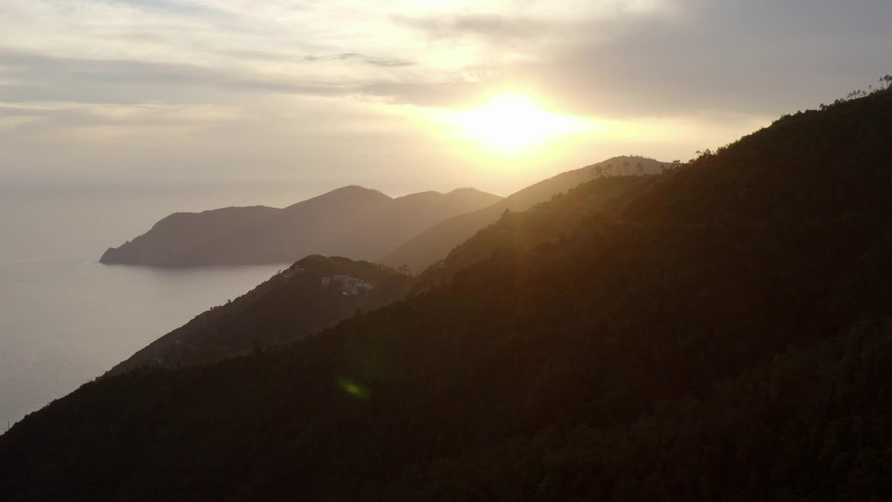 空中前进的内陆湖风景在多云的天空，无人机在日落时飞越山脉视频素材