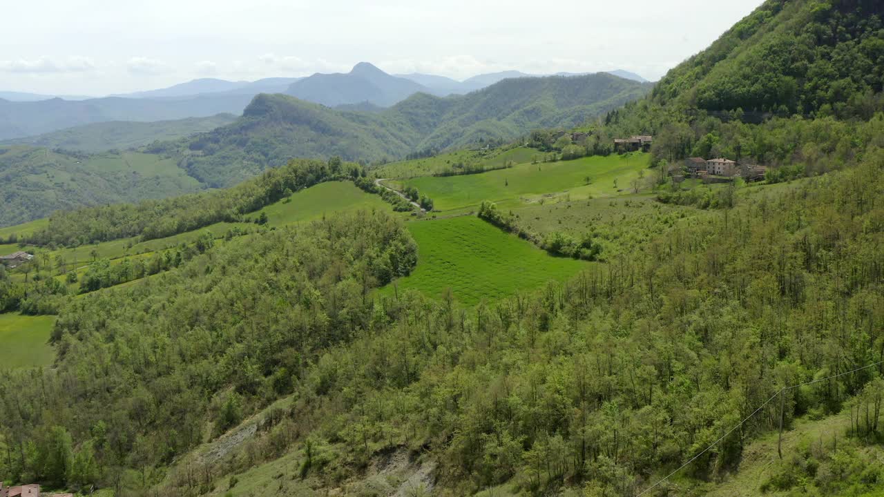 空中拍摄的山坡上的建筑，无人机在绿树上降落-亚平宁山脉，意大利视频素材