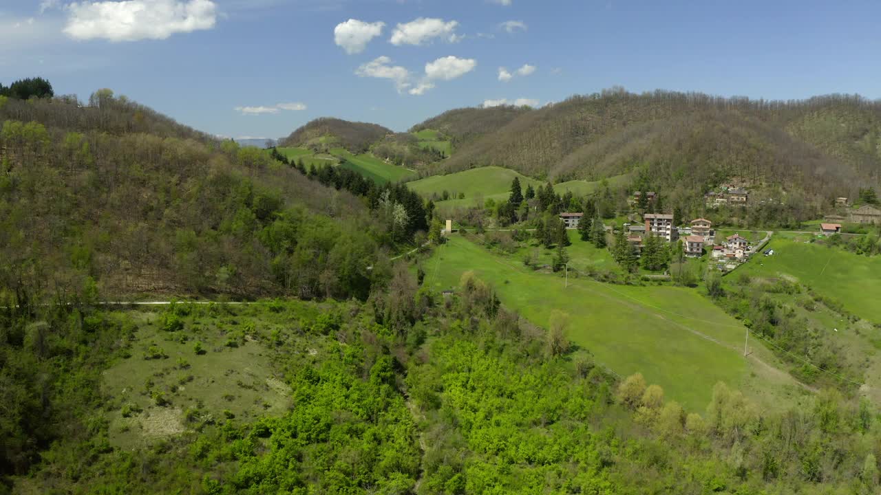 绿色景观上的空中建造住宅，无人机在阳光下飞行-意大利亚平宁山脉视频素材