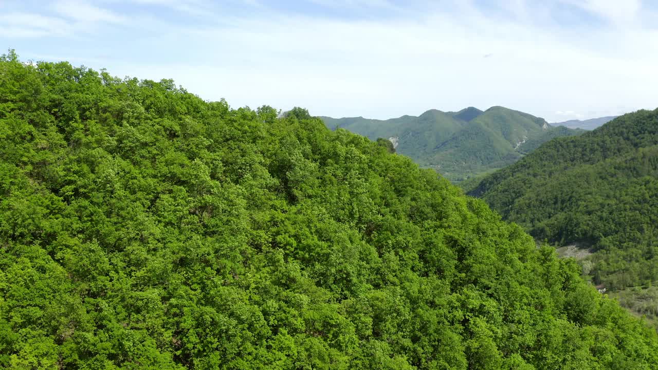 空中:在多云的天空下绿色山脉的美丽视图，无人机飞过森林-亚平宁山脉，意大利视频素材