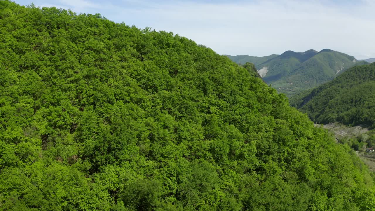 空中美丽的绿色天然小山对多云的天空，无人机飞过房子-亚平宁山脉，意大利视频素材