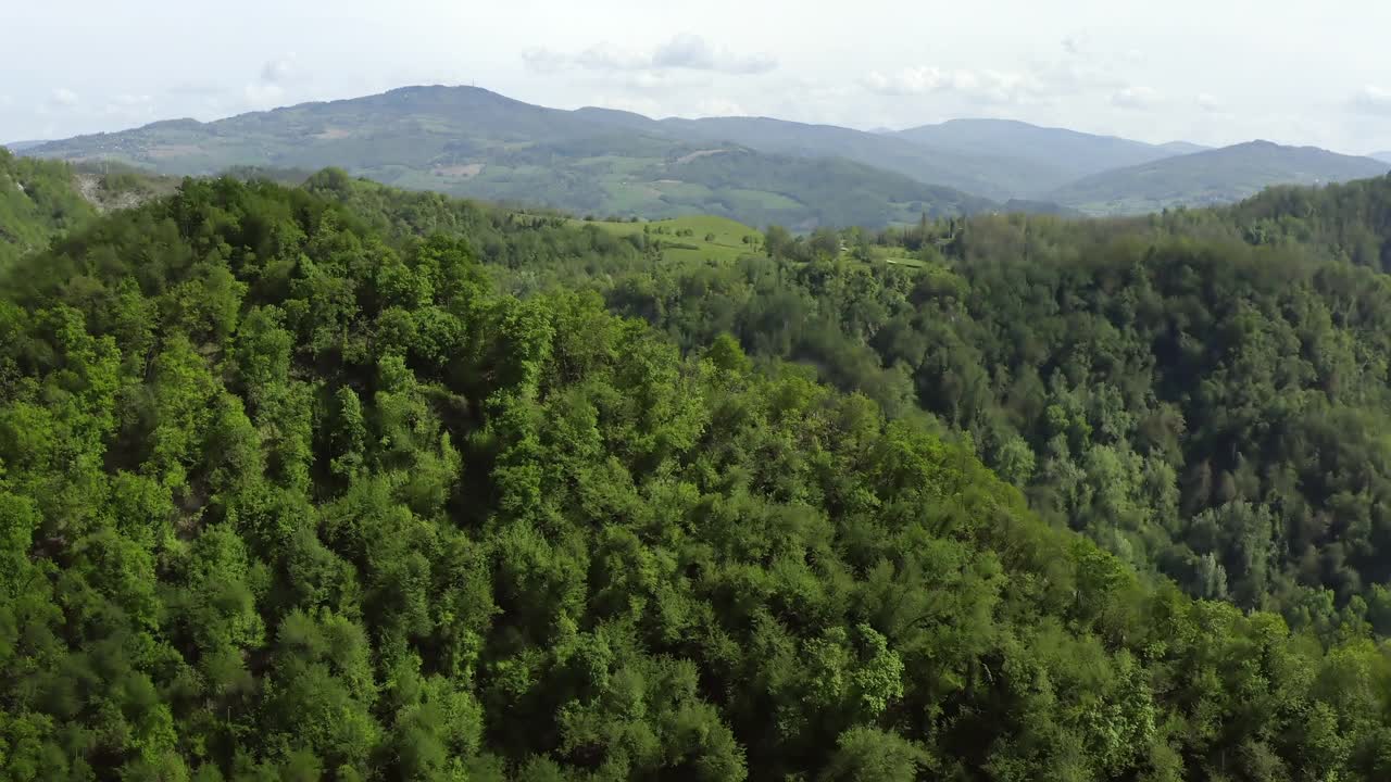 在多云的天空下的天然山丘的鸟瞰图，无人机飞过绿色森林-亚平宁山脉，意大利视频素材